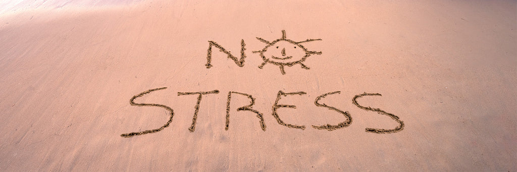 NO STRESS written in sand on a beach