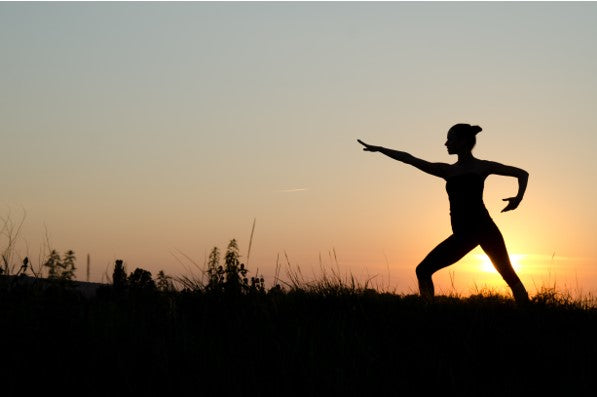 Woman doing yoga in sunset